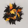 Halloween candle ring with black and orange artificial maple leaves and small pumpkin decoration. - Black Maple Leaf Yellow Pumpkin Candlestick