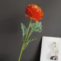 Close-up detail of artificial ranunculus flower with natural touch for home decor staging. - Orange Red