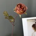 Detalle de rosa artificial vintage, tela borde quemado decoración floral estética. - Naranja
