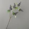 Detalle de rama de bayas artificiales, frutos morados oscuros y hojas para la decoración. - Azul