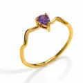 Close-up of a unique wavy gold stainless steel ring featuring a sparkling purple pear zircon. - Gold Style 6