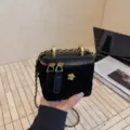 Bolso vanity negro de terciopelo acolchado con correa de cadena dorada y camelia de metal. - S / Negro