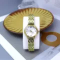 Detailed view of women fashion gold quartz watch with radial pattern dial and steel strap. - White