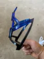 Detailed view of the blue-black gradient bicycle water bottle cage made of thick plastic. - Blue