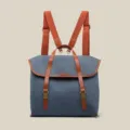 Detailed view of vintage denim backpack with brown leather straps and chic canvas texture. - Blue