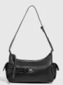 Close-up of black leather shoulder bag with contrast white stitching and front pocket detail. - Black