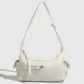 Close-up detail of the white crescent underarm bag, showing zipper pocket and side parts. - Off White