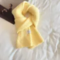 Close-up detail of yellow ribbed knit scarf, cozy winter texture and soft warm fabric. - Milk Yellow