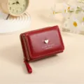 Women's short red leather wallet with cute metal heart charm, compact zipper coin purse. - Red