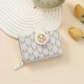 White PU short wallet with M monogram print, compact folding design with zipper coin pocket. - White