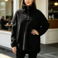 Detail view of black fleece half-zip sweatshirt featuring cozy high collar and soft texture. - S / Tops / Black