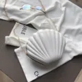 Bolso cruzado de concha en charol blanco de tendencia con cadena dorada, variante elegante. - Blanco