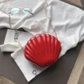 Bolso bandolera rojo de charol en forma de concha con cadena dorada para mujeres elegantes. - Rojo