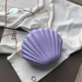 Bolso cruzado de charol morado con diseño de concha y elegante correa de cadena dorada. - Púrpura