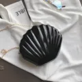 Borsa a tracolla a conchiglia in pelle verniciata nera con catena dorata, design chic. - Nero