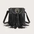 Detailed view of black fringe crossbody bag with metal skull ornament and rivet studs. - Black Small
