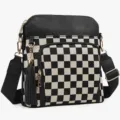 Black and white checkered crossbody shoulder bag with leather trim and tassel detail. - Black