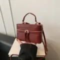 Brown structured vanity box handbag featuring a top handle and a detachable strap. - Red PU Style