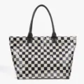 Close-up detail of black and white checkered tote bag with patent leather handles. - Checkerboard Black