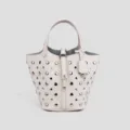 White leather bucket bag with silver metal studs, top handle and padlock closure. - White
