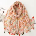 Detail view of a vintage floral print cotton linen scarf with colorful tassel trim and elegant design. - Red Series 29
