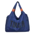 Bolso de hombro de nailon azul con detalles marrones y llamativo estampado de letras delante. - Azul