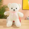 Primo piano dettaglio di simpatico orsacchiotto di peluche bianco con fiocco rosa su scrivania. - 40CM / Velluto di Rosa Bianco