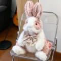 Vue détaillée du mignon sac en peluche lapin rose et blanc avec nœud floral et longues oreilles. - 50 cm / Rose