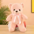 Detailed view of a cute pink teddy bear plush toy with a soft ribbon bow, perfect for kids. - Flesh Pink