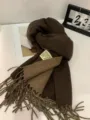 Detailed shot of a stylish brown winter scarf with tassels and label for cozy warmth. - Double-Sided Coffee