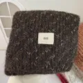 Dark brown knit scarf detail, soft woolen texture with center woven label, cozy winter wear. - Brown