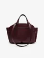 Détail de sac à main en cuir bordeaux, avec double poignées et soufflets latéraux structurés. - Rouge Foncé