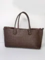 Dark brown woven leather tote bag detail, featuring intricate intrecciato handcrafted design. - L / Burgundy