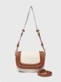 Detailed view of women canvas saddle bag with brown leather trim and adjustable strap. - S / Brown and White