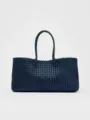 Vista detallada del elegante bolso tote de cuero tejido en azul oscuro con asas clásicas. - L / Azul marino