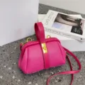 Elegante borsa a mano rosa in pelle testurizzata con manico superiore e tracolla. - Rosa intenso