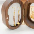 Exquisite beaded drop earrings detail featuring purple stones and a gold-tone disc pendant. - Rouge Red