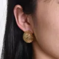 Close-up detail of textured woven gold dome earrings worn on ear, elegant chic design. - Mesh Woven Style (LK-EH)