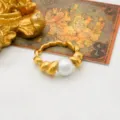 Elegant stainless steel 18k gold plated twisted ring featuring a classic white pearl charm. - Size 6 / Pearl