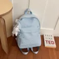 Vue rapprochée du sac à dos bleu clair étoilé avec pendentif étoile en dentelle et bretelles. - Avec Pendentif / Bleu