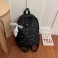 Vue détaillée du sac à dos décontracté à imprimé étoiles noir avec pendentif étoile en dentelle. - Avec Pendentif / Noir