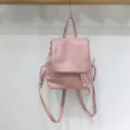 Pink women backpack detail shot, minimalist design with drawstring and flap closure style. - Pink