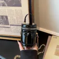 Mini sac seau cylindrique en cuir verni brillant avec chaîne dorée pour enfants. - Noir