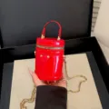 Petit sac cylindrique rouge verni pour enfants, élégant sac à bandoulière en cuir verni. - Rouge