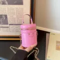 Mini sac bandoulière cylindrique en cuir vernis rose avec chaîne dorée pour enfants. - Rose