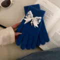 Detail view of blue knit gloves featuring elegant white lace, ribbon bow, pearls, and rhinestones. - Rhinestone Bowknot Full Finger Style / Dark Blue
