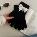 Close-up detail of black knitted winter gloves featuring elegant pearl and bow design. - Rhinestone Bowknot Full Finger Style / Black