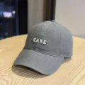 Grey washed cotton baseball cap detail showing clean CARE letter embroidery and fine stitching. - Adult 54-60 Adjustable / Gray
