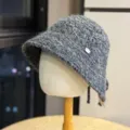 Gray textured knitted bucket hat closeup showcasing cozy winter fabric and neat metal logo detail. - Adult One Size (54-60cm) / Black