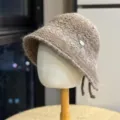 Detailed view of the stylish brown textured bucket hat with metal tag accent, cozy and warm. - Adult 54-60 One Size / Coffee